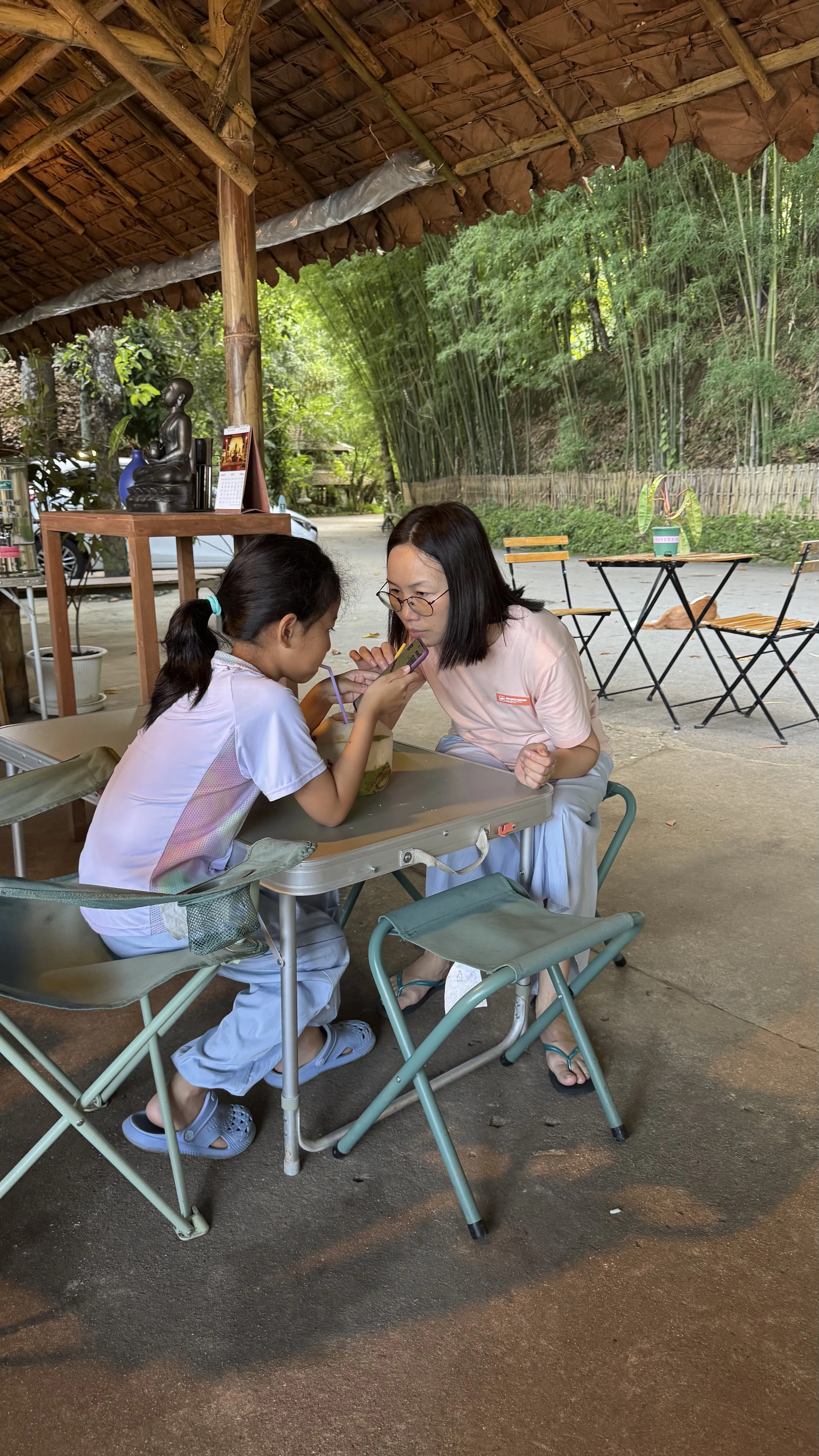 Wat Pha Lad 棚子下，母女俩坐在小桌两侧